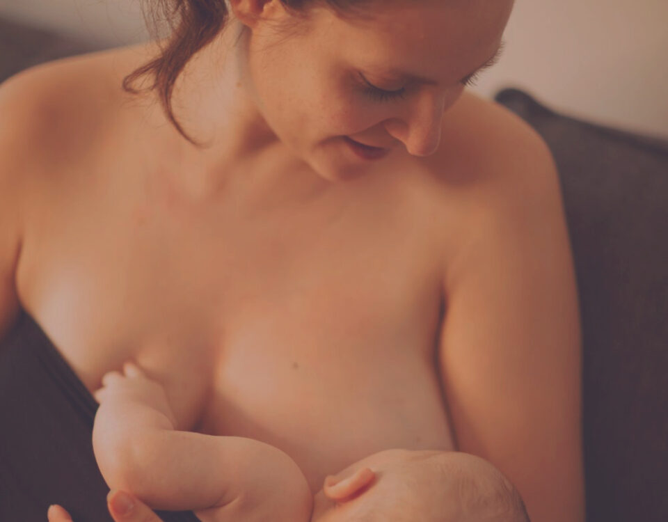 Mutter stillt Baby im Wochenbett