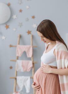 Schwangere Mama freut sich auf ihr Baby und hält ihren Bauch